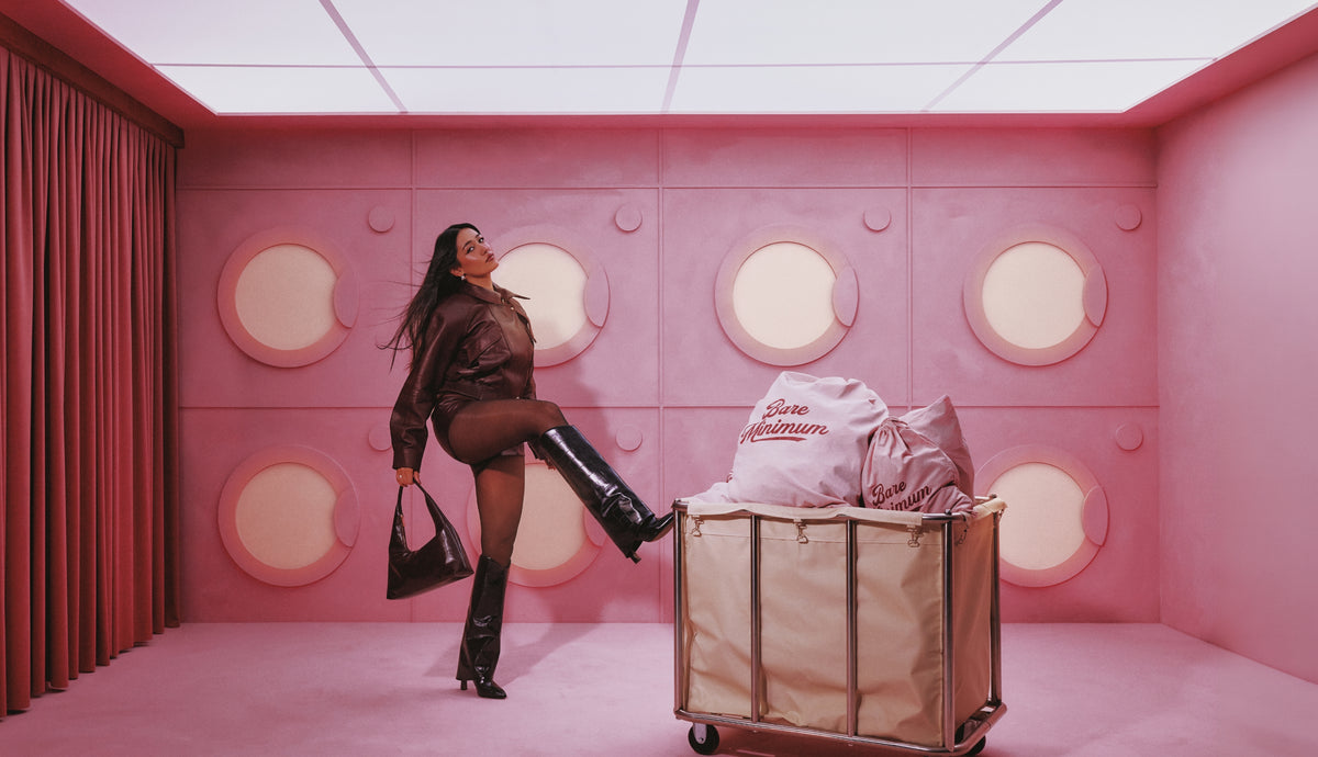 Women wearing a black high boot in a pink room